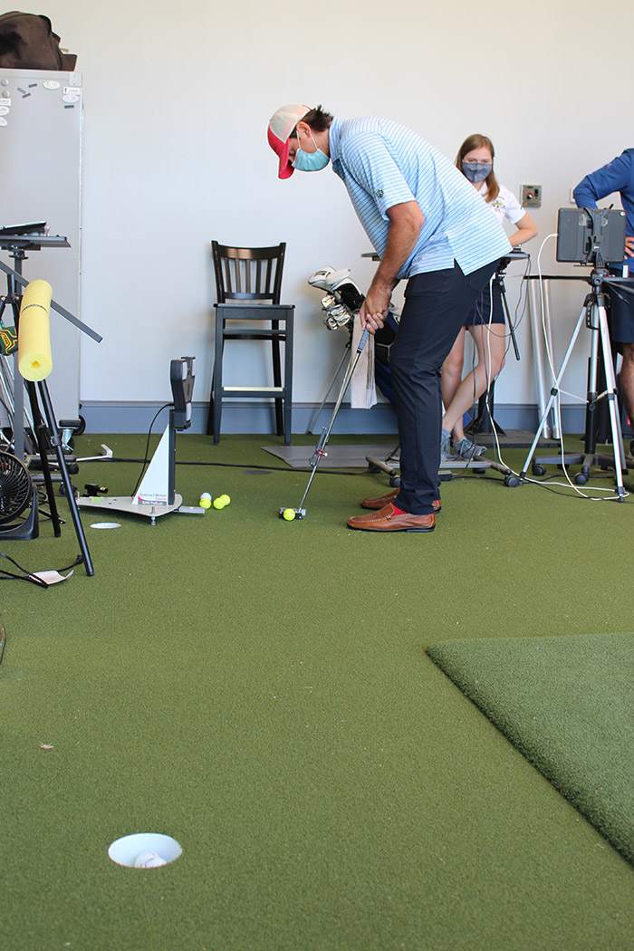 Reagan Cink takes a few test putts at the Bobby Jones Golf Course Bandy Instructional Center using a 3D-printed putter designed by undergraduate Caroline Means (just behind Cink). (Photo: Joshua Stewart)