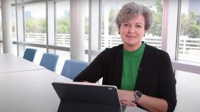 Cristi Bell-Huff sits at a conference table with her tablet computer.