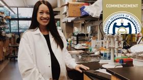 A pregnant Midori Wasielewski in lab coat stands in her lab at Georgia Tech.