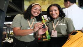 Two senior BME students holding a device their group designed for Georgia Tech's Capstone Expo in April 2023