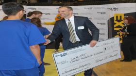 James Rains congratulates a Capstone team during the Design Expo.