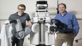 Left to right: Zackory Erickson, a PR2 robot, and Charlie Kemp
