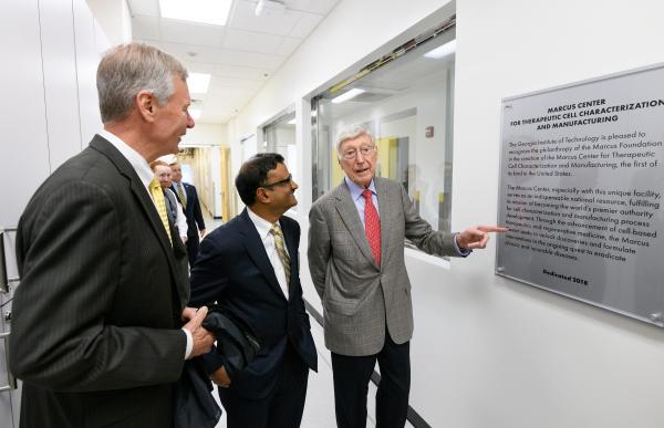 A plaque is unveiled in the new Good Manufacturing Practice (GMP) like facility that is part of the Marcus Center for Therapeutic Cell Characterization and Manufacturing (MC3M). Shown are Georgia Tech President G.P. “Bud” Peterson, Center Director Krishnendu Roy, and philanthropist Bernie Marcus. (Credit: Rob Felt, Georgia Tech)