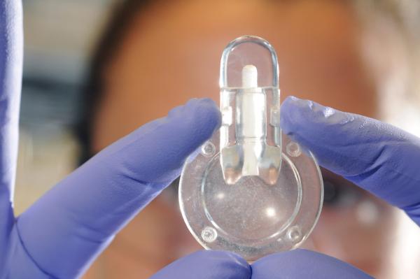 Erika Tyburski is shown with a prototype device for point-of-care testing of anemia. The device could enable more rapid diagnosis of the common blood disorder and allow inexpensive at-home self-monitoring of persons with chronic forms of the disease. (Photo: Gary Meek)