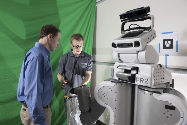 Charlie Kemp and Zackory Erickson prepare the robot.