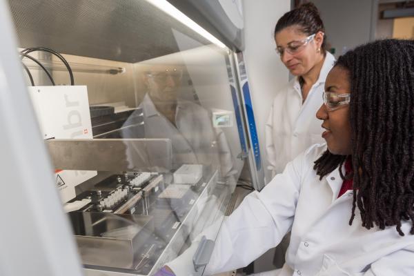 Research Scientist Sommer Durham and Research Technician Naima Djeddar set up and initiate process steps for automated cell culture on the AMBR 15 micro-bioreactor in the Engineered Biosciences Building at Georgia Tech. (Credit: Rob Felt, Georgia Tech)