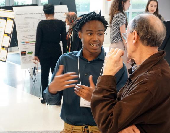 Kendreze Holland, a 2019 Petit Scholar, discusses his research at a recent poster session.