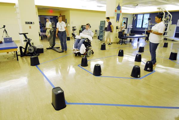 Jason DiSanto navigates an obstacle course in an electric-powered wheelchair by issuing commands with a magnetic tongue piercing. The 50-meter-long course, at the Shepherd Center in Atlanta, Ga., included 13 turns and 24 obstacles, requiring tongue drive users to make U-turns, move in reverse and negotiate a loop. Joy Bruce stands to DiSanto's immediate right. Credit: Gary Meek