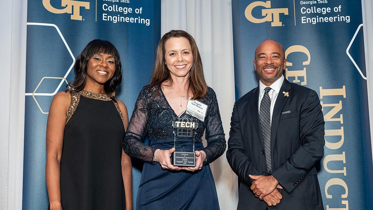 Angela Gill Nelms, center, at the Georgia Tech College of Engineering's annual awards gala April 23 with hosts Wonya Lucas, left, and Dean Raheem Beyah. Nelms, B.S. BME 2007, was inducted into the Academy of Distinguished Engineering Alumni at the event. (Photo: Gary Meek)