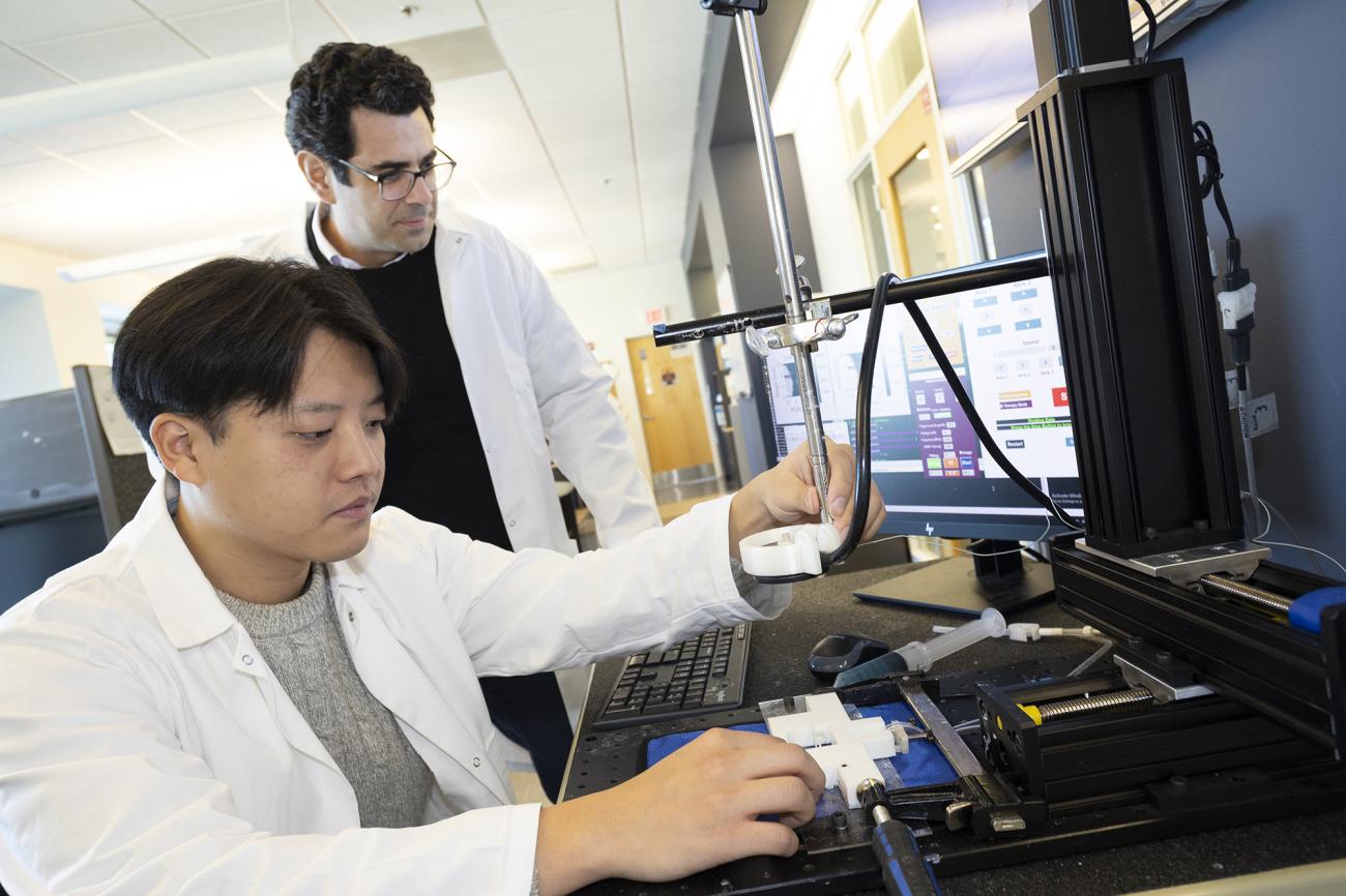  Associate Professor Costas Arvanitis and mechanical engineering Ph.D. student Hohyun "Henry" Lee with their closed-loop controlled focused ultrasound system. The system uses ultrasound-induced microbubbles to help a powerful immunotherapy target brain tumors and a custom algorithm to continuously fine tune the bubbles for maximum impact.